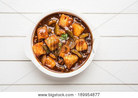 Spicy Paneer or chilli paneer or cottage cheese, served in white Dish with capsicum and onion, favourite indian starter menu, selective focus