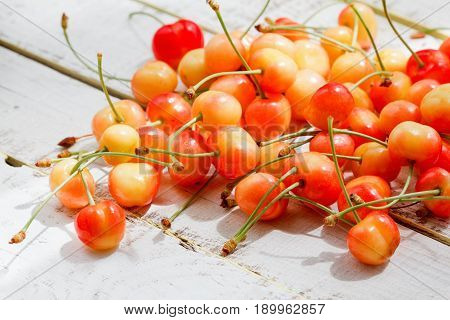 Ripe sweet cherry on a painted wooden background
