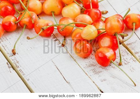 Ripe sweet cherry on a painted wooden background