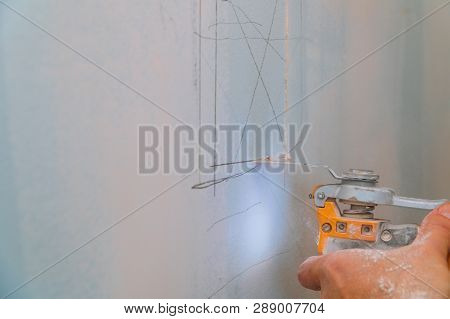 Man Is Cutting Gypsum Board Drywall Panel With Electro Knife Repair Works Renovation In Restoration 