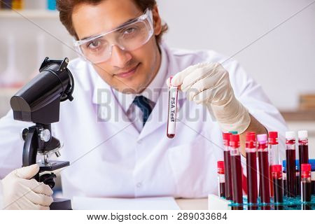 Young handsome lab assistant testing blood samples in hospital 