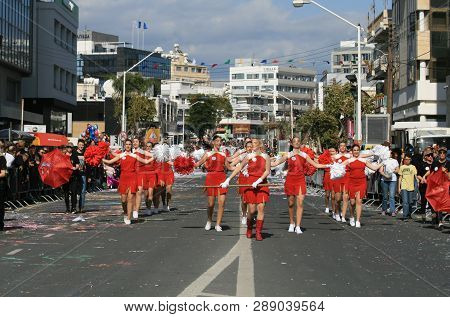 Limassol, Cyprus, March 10th, 2019: Group Of Drum Majorettes In Red Costumes With Pom-poms Marching 