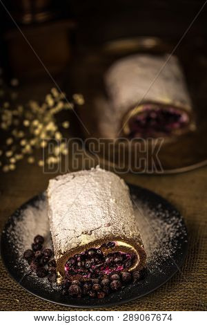 Black Currant Roll On A Plate With With Black Currant Berries On The Table