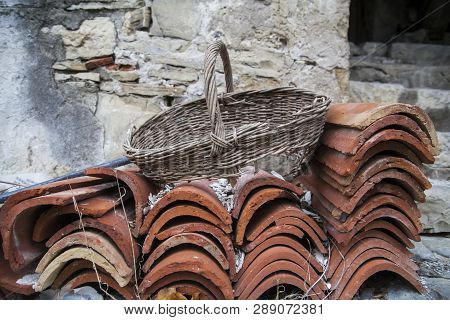 Broken Basket On A Pile Of Clay Roof Tilesin An Abandoned Village Slapnik In Region Goriška Brda, Sl