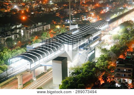 Aerial Shot Of Lit Metro Sation With Trails From Leaving Train And Traffic