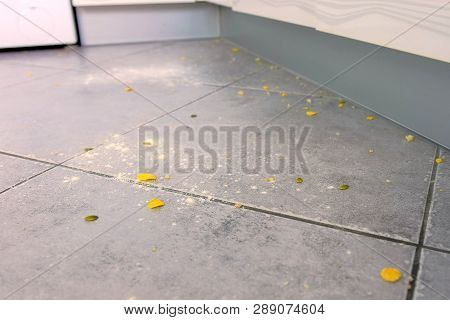 Dirty Kitchen Floor With Food Leftovers, Flour, Corn Flakes After Cooking. Close-up View.