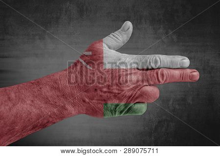 Oman Flag Painted On Male Hand Like A Gun