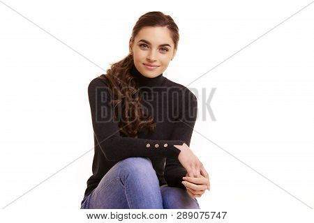 Attractive Smiling Young Woman Sitting At Isolated White Background