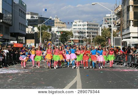 Limassol, Cyprus, March 10th, 2019: Teenage Girls In Bright Multi Colored Dresses Walking Along Arch