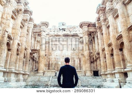 Man Looking On Historic Ancient Roman Bacchus Temple In Baalbek, Lebanon