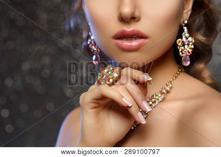 Diamond ring on the hand of a beautiful woman. Brilliant.  Antique old vintage earrings and ring. Jewelry on girl finger with lux manicure