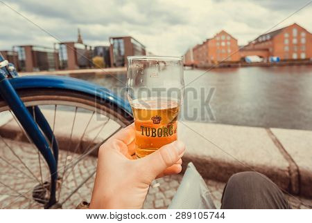 Copenhagen, Denmark - Sept 5: Beer Tuborg In Firm Glass And Calm Cityscape, Byicycles, Water Channel