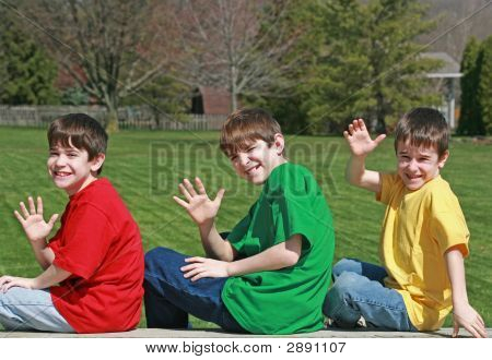 Drie jongens zwaaien