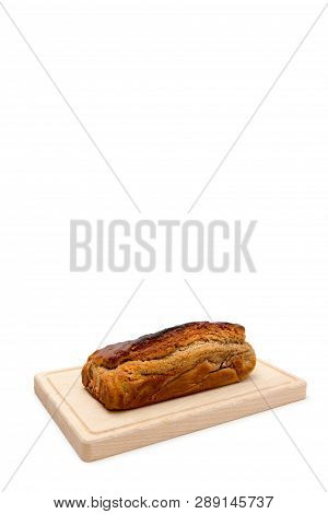 A Homemade Plumcake Standing On A Wooden Board With A White Background