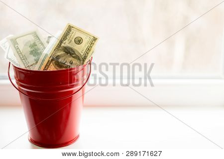 Dollar Bills In Red Pail. On White Window.light Background. Place For Text. Top View. A Lot Of Money