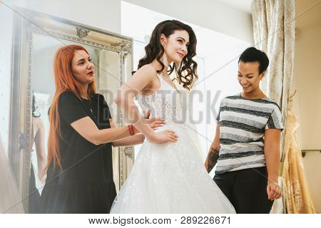 Beautifu bride choosing wedding dress in a wedding salon