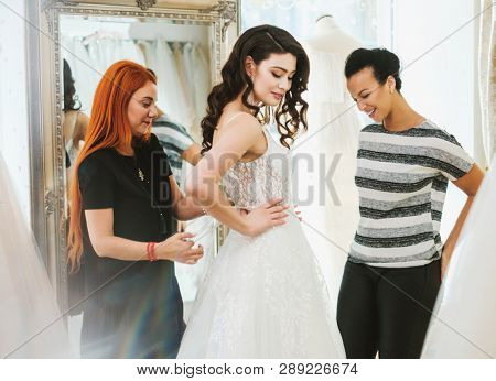 Beautifu bride choosing wedding dress in a wedding salon