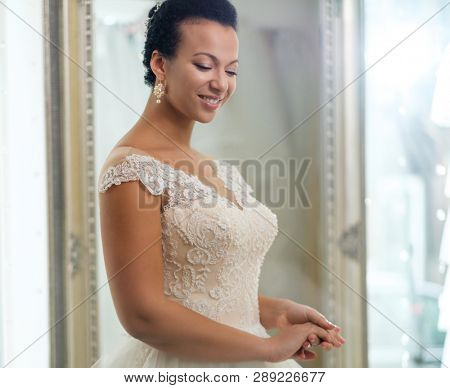 Beautifu bride choosing wedding dress in a wedding salon