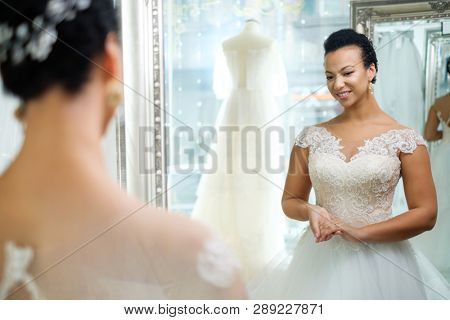 Beautifu bride choosing wedding dress in a wedding salon