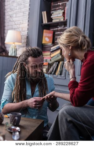 Nice Joyful Man Reading The Palm Of His Client