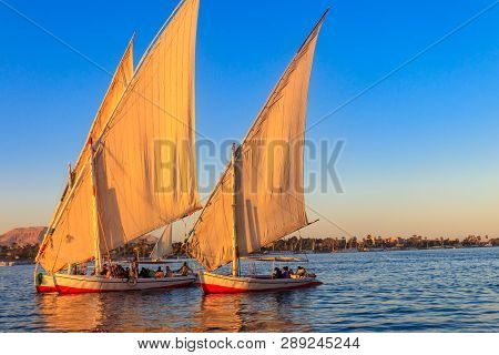 Felucca Boats Sailing On The Nile River In Luxor, Egypt. Traditional Egyptian Sailing Boats