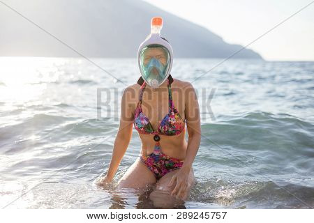 Caucasian Young Woman In Mask For Snorkling Sitting In Shallow Water On Beach