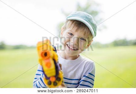 Happy Young Boy With Toy Weapon Outdoors