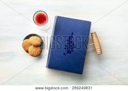 A Photo Of An Old Book With A Vintage Corkscrew Used As A Bookmark, With A Glass Of Sweet Wine With 