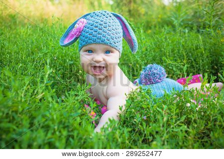 Easter Holidays For Happy Kids. Cute Baby In Rabbit Of Lamb Costume In The Green Spring Grass. Smili