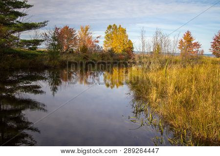 Autumn Reflections Landscape. Vibrant Fall Foliage Reflected In A River Flowing Through The Hiawatha