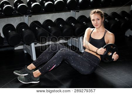 Young Fitness Sport Girl Doing Abdominal Exercises With Weight Barbell Plate In Gym.woman In Sportsw