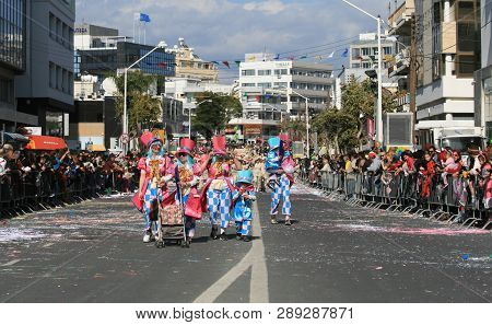 Limassol, Cyprus, March 10th, 2019: Group Of People In Bright Carnival Costumes And Top Hats Walking