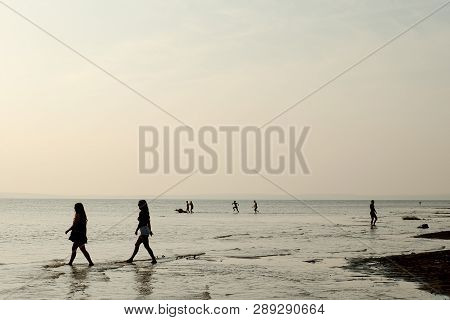 People Silhouette On The Coast Of The Sea. Sepia Effect