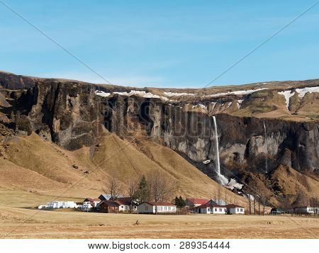 Basalt Cliff, Foss A Sidu Waterfall And Farm, With Blue Sky In Winter Seen From Road 1, Southern Ice