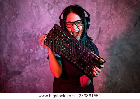 Professional Girl Gamer In Mmorpg Strategy Video Game. Shes She Posing Over Colorful Blue And Pink B