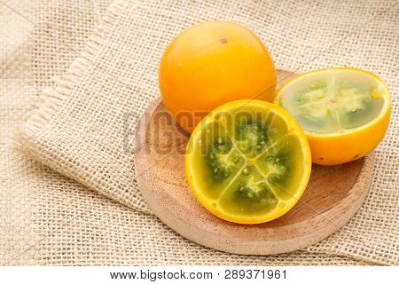 Fruits And Slices Of Lulo Or Naranjilla On The Wooden Table - Solanum Quitoense
