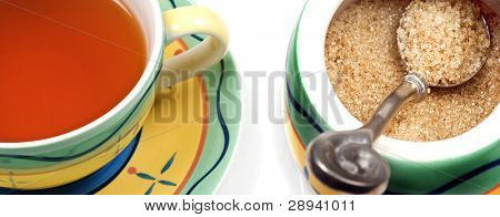 Nahaufnahme von einer Tasse gesunde gesunde grüner Tee und eine Schale mit brauner Zucker