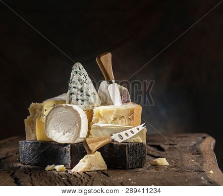 Assortment of different cheese types on wooden background. Cheese background.
