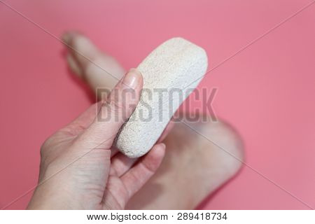 Pumice Stone For Foot Care. In The Photo A Woman Hand Holds A Pumice Near The Heel Of Her Foot. Remo