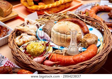 Decorated Sausages With Fresh Vegetables, Bread And Bottle Of Brandy Are Exposed On Traditional Saus