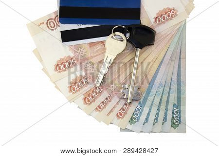 Metal keys on a horizontal background of a variety of banknotes of five and one thousand Russian rub