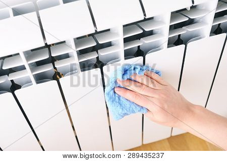 Employee Hand In Rubber Protective Glove With Micro Fiber Cloth Wiping A Heater Radiator