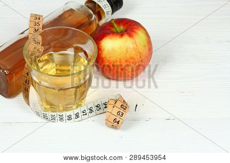 Apple Vinegar And Apples. Fresh Apple, Apple Vinegar, Measuring Tape And Glass On White Wooden Table