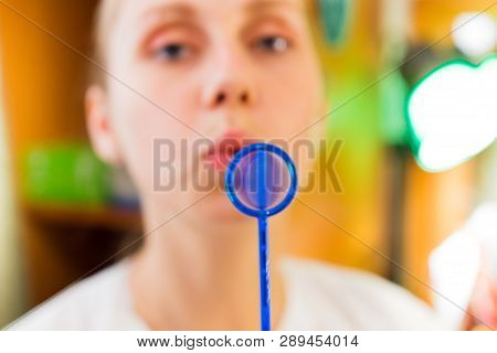 Young Woman Trains With Speech Therapy Probe In Soft Focus.