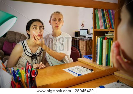Speech Therapist Teaches A Young Girl The Correct Pronunciation Of Speech.