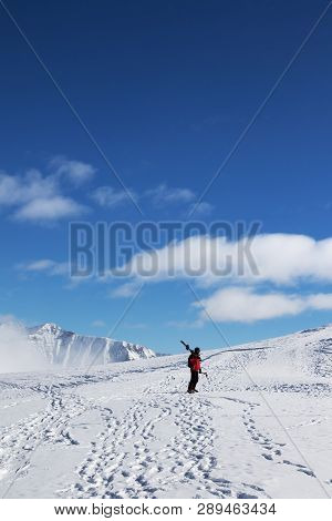 Skier With Skis On His Shoulder And Snowy Mountain In Cold Sun Day. Winter Caucasus Mountains, Georg