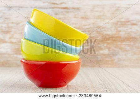 Ceramic Bowl Assorted Colors On Wooden Background