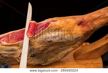Close-up Of A Knife Cutting A Spanish Serrano Ham