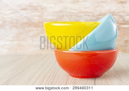 Ceramic Bowl Assorted Colors On Wooden Background