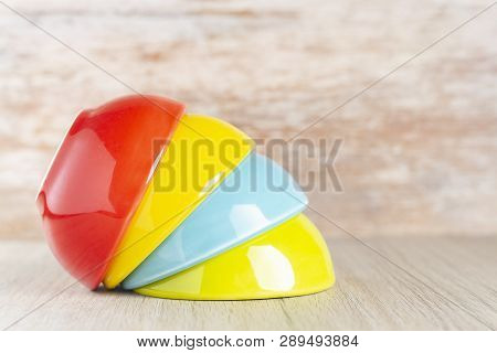 Ceramic Bowl Assorted Colors On Wooden Background, Close-up
